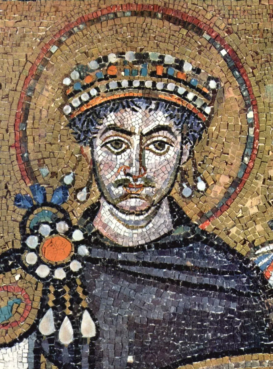 Mosaico de San Vitale: o imperador Justiniano de coroa e auréola dourada, com manto roxo preso por um broche no ombro