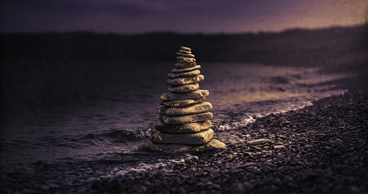 Figuras geométricas riscadas na areia de uma praia deserta, com o graveto largado ao lado.