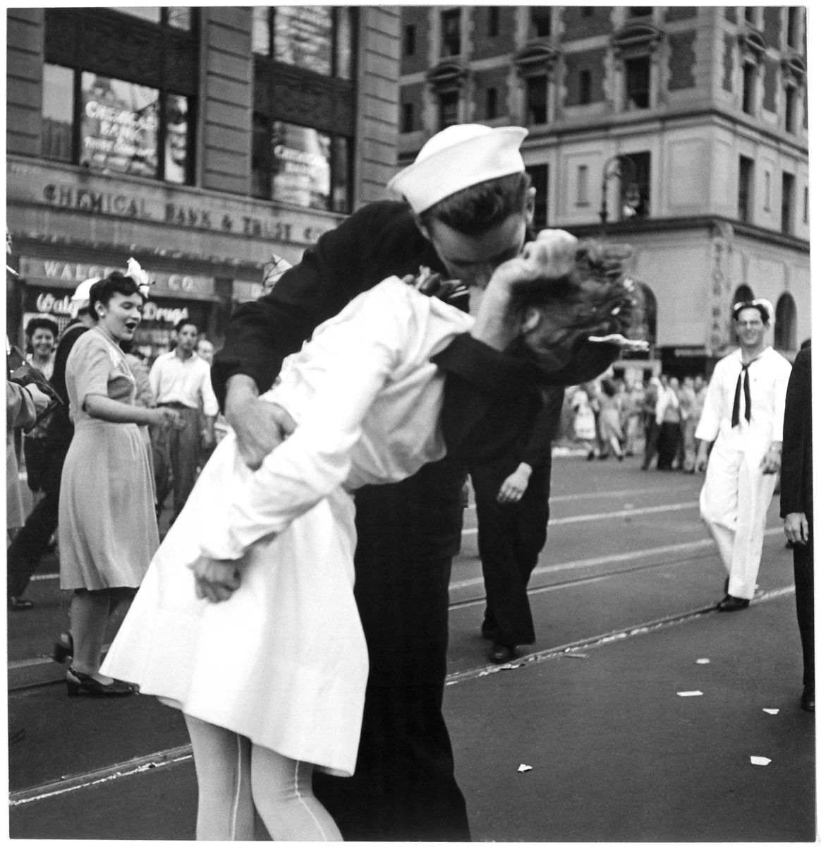 Marinheiro de uniforme escuro beijando uma moça de vestido branco no meio da Times Square, em Nova York, no dia do anúncio do fim da guerra, em 14 de agosto de 1945.