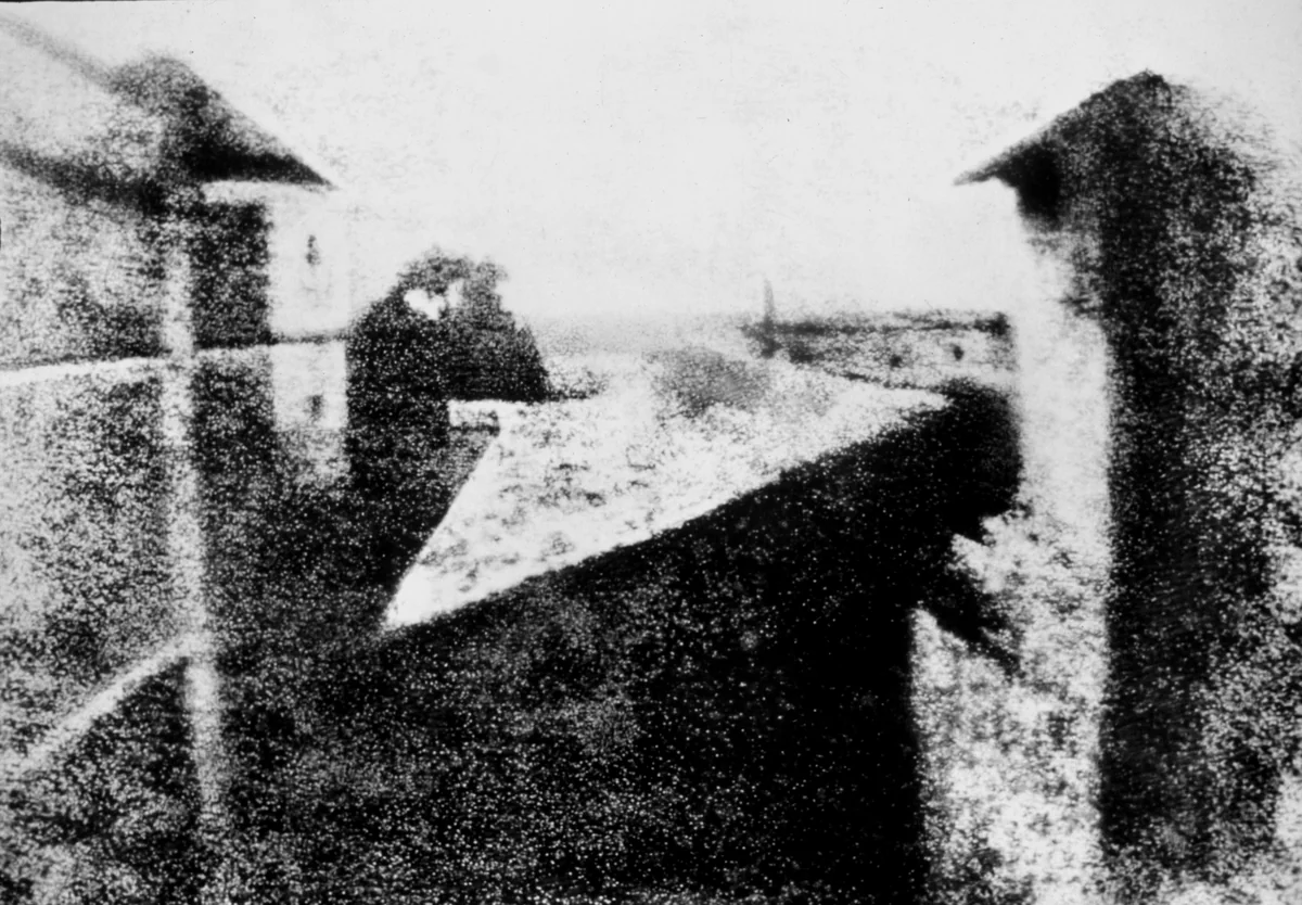 Vista da janela em Le Gras, placa de estanho heliogravada por Joseph Nicéphore Niépce em 1826, mostrando telhados e o pátio da propriedade.