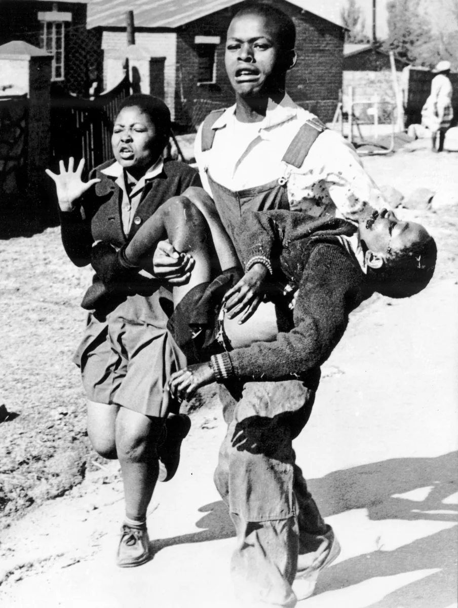 O estudante Mbuyisa Makhubo carrega Hector Pieterson, ferido durante o levante de Soweto, ao lado da irmã Antoinette, em 16 de junho de 1976.