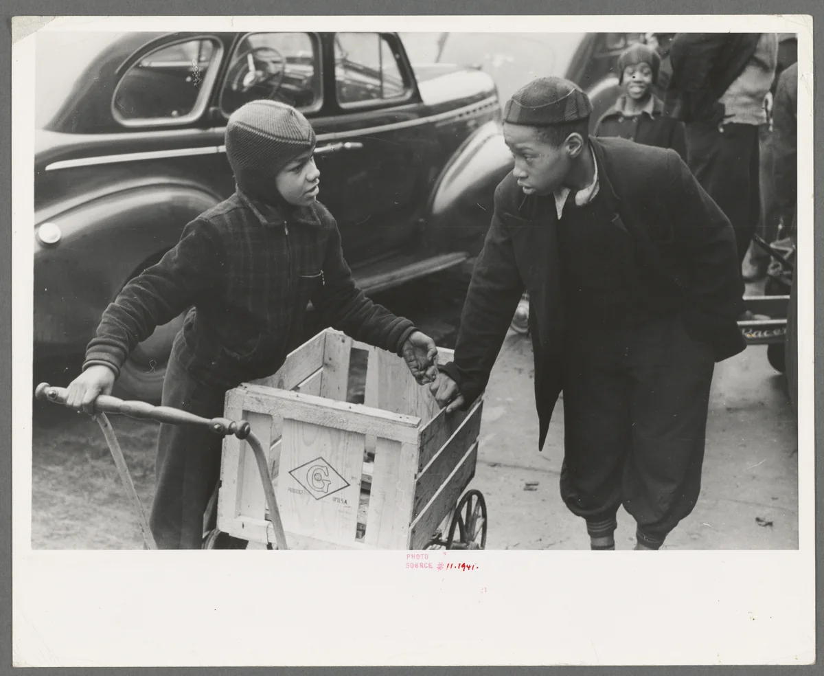 Meninos parados na calçada em frente a um mercado A&P no South Side de Chicago, à espera de trabalho carregando compras, fotografados por Russell Lee para a Farm Security Administration em abril de 1941.