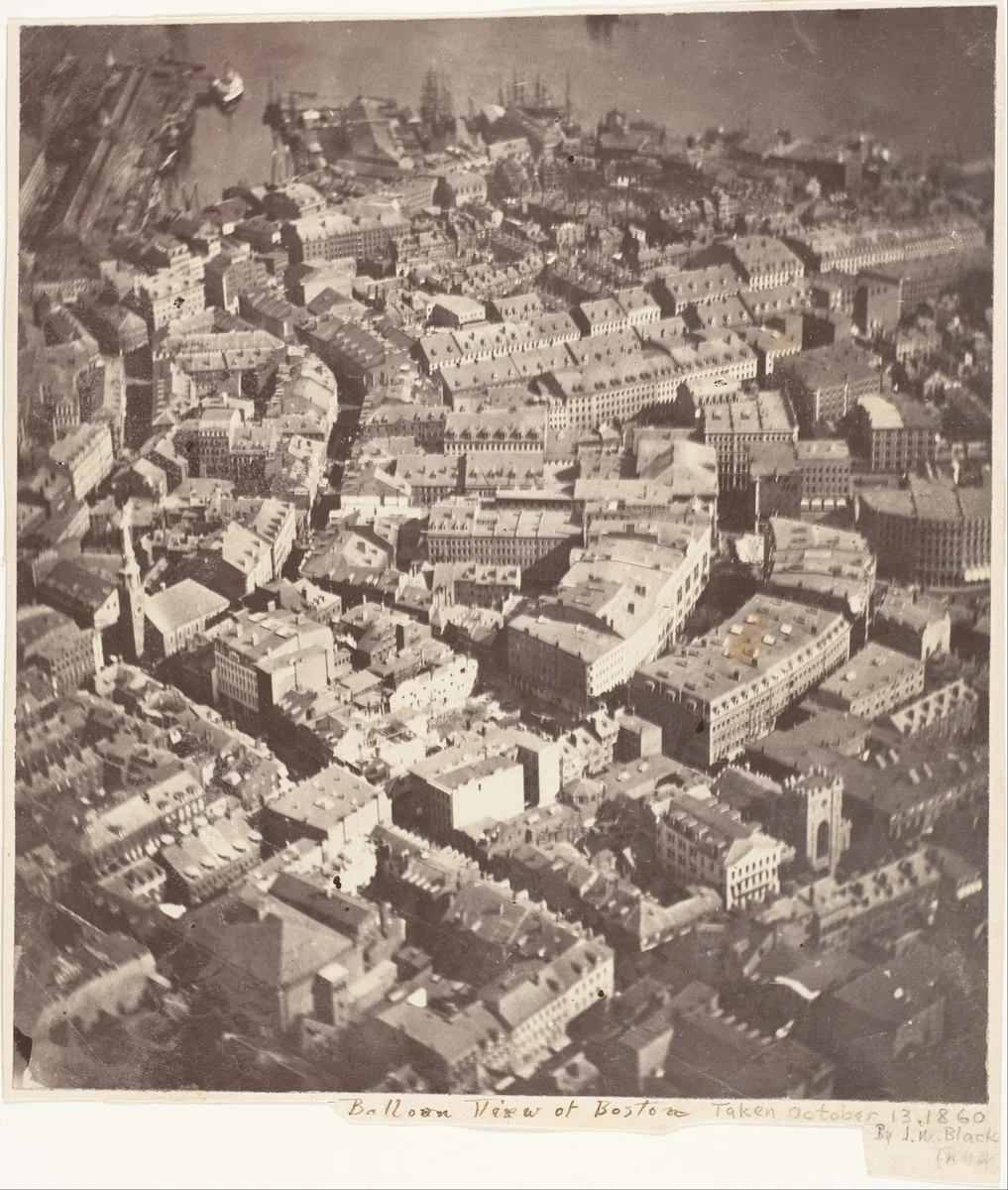 Vista aérea do centro de Boston em 1860, com telhados, chaminés, a torre da Old South Meeting House e mastros no porto.
