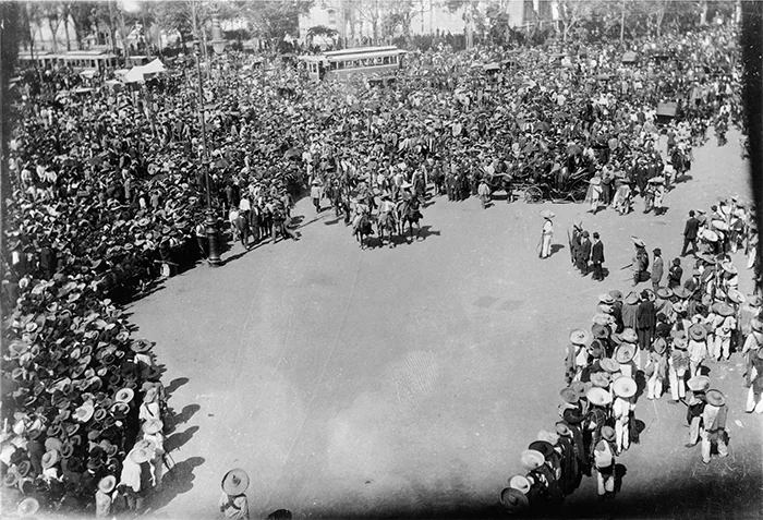 Coluna de zapatistas com chapéus de palha a cavalo e a pé diante do Palácio Nacional, no Zócalo da Cidade do México, foto creditada a Agustín Casasola, 1914.