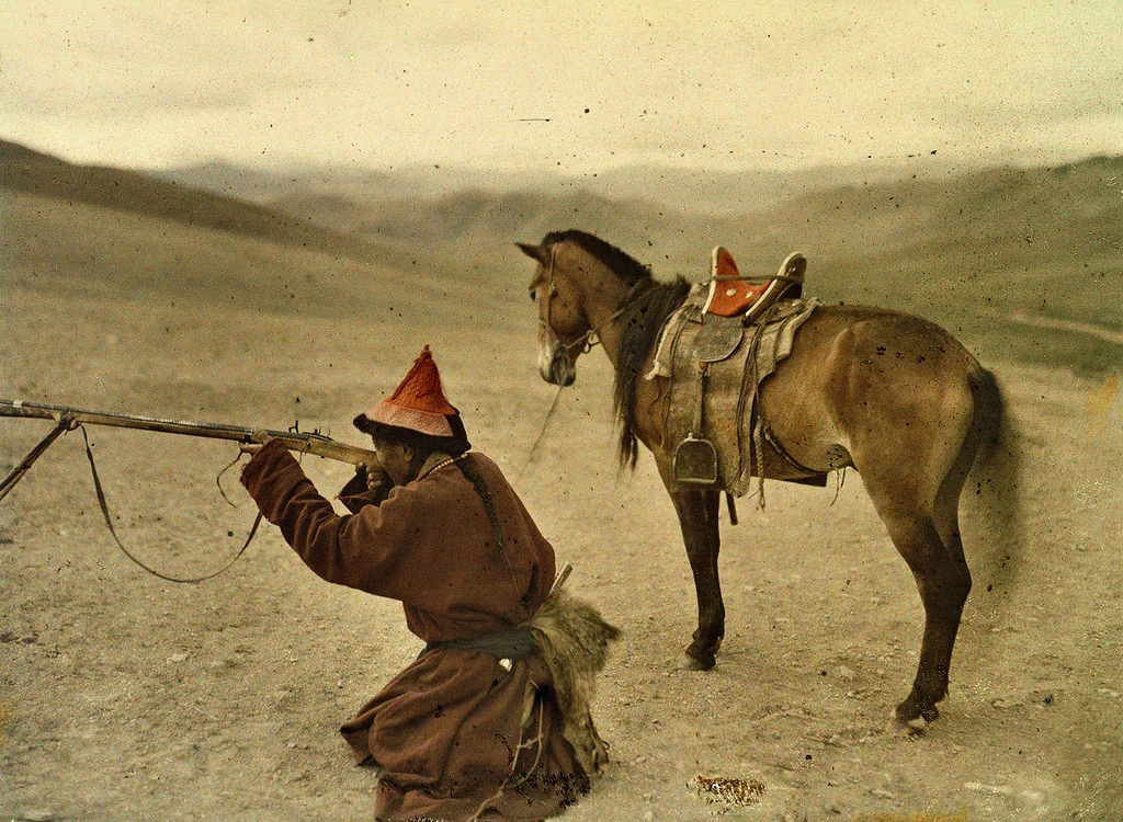 Autocromia de Stéphane Passet, 1913: caçador mongol de casaco longo, de pé na estepe perto de Urga