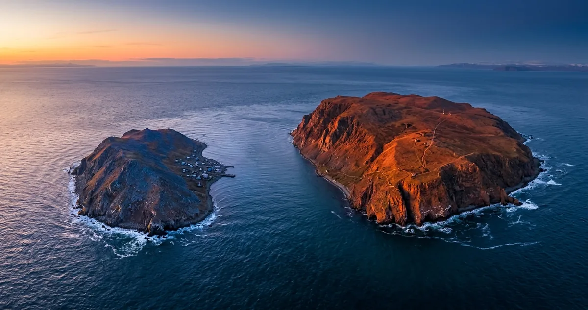 Vista aérea das duas ilhas Diomedes no estreito de Bering, separadas por um canal estreito de mar gelado.