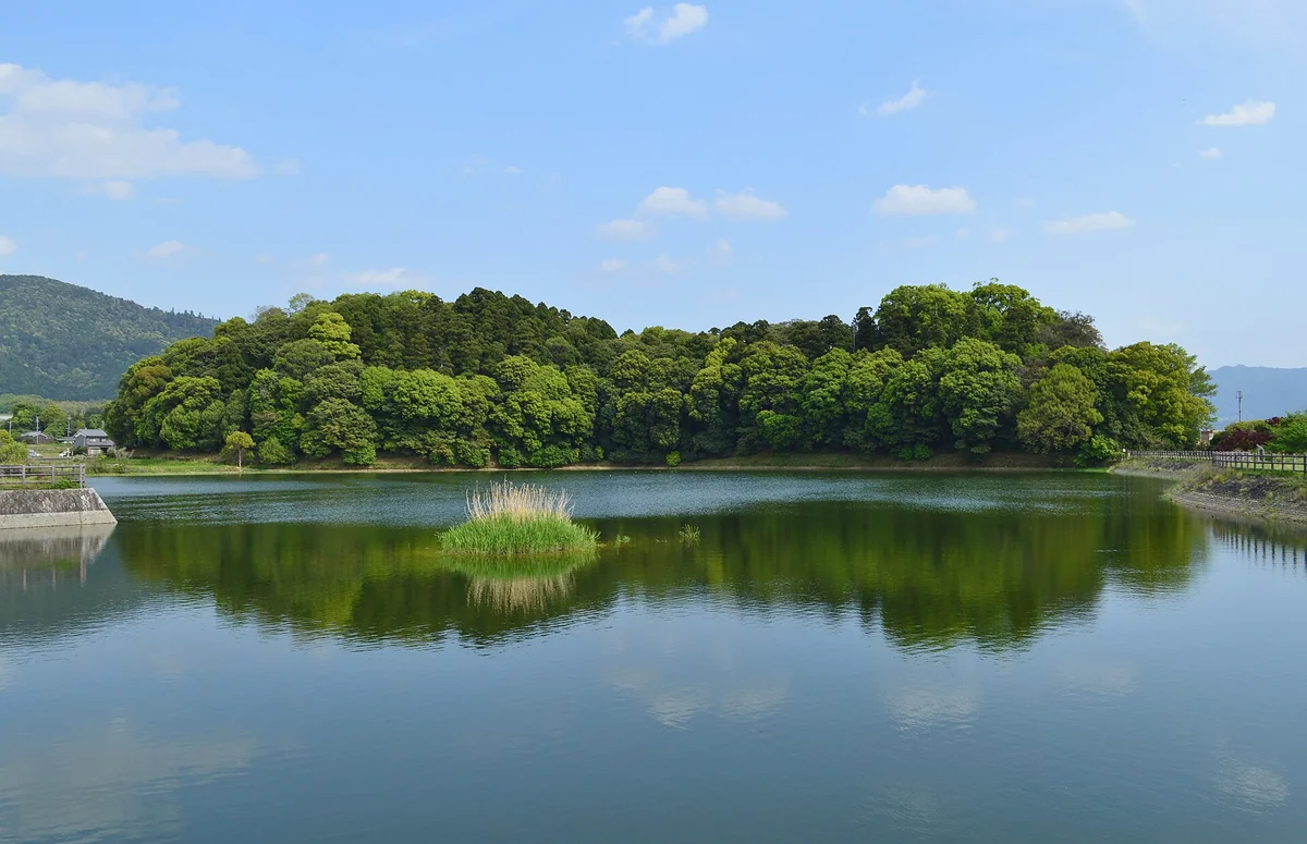 O montículo arborizado do Hashihaka, em Sakurai, na planície de Nara, cercado pelo fosso.